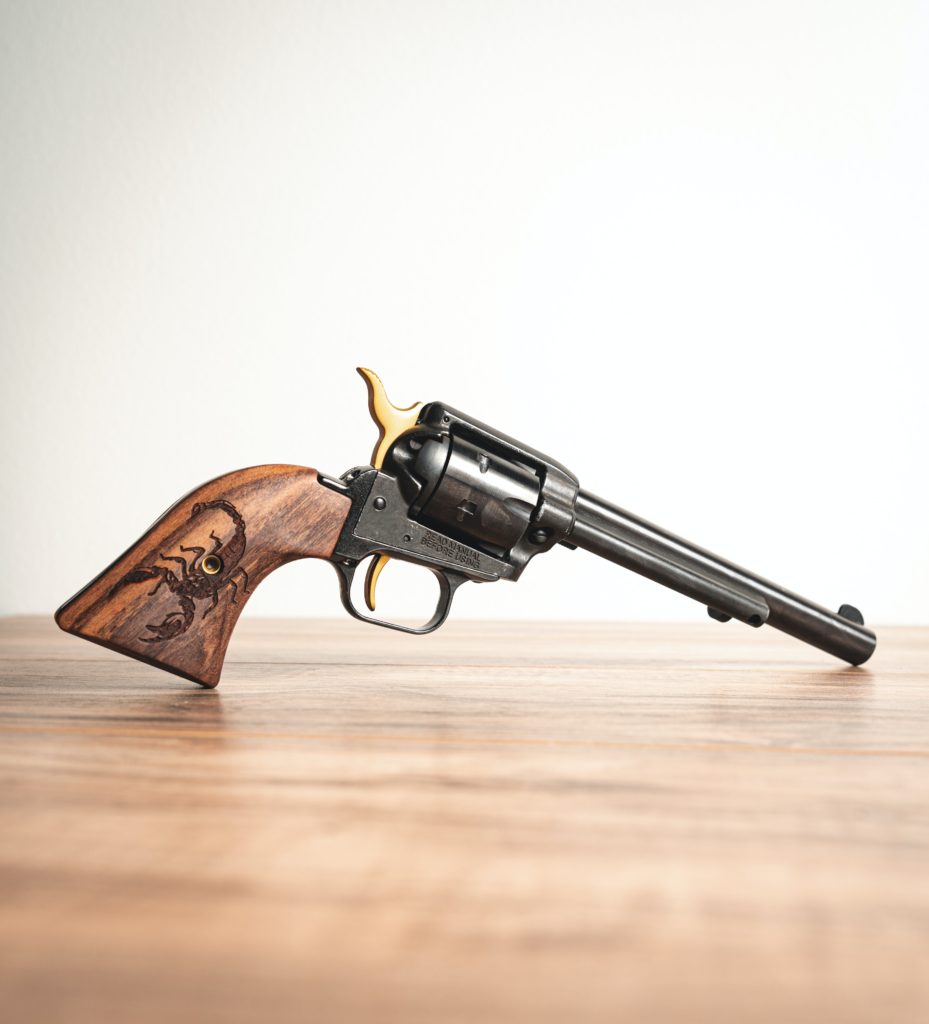Wooden Handled Revolver Sitting on a Wooden Table